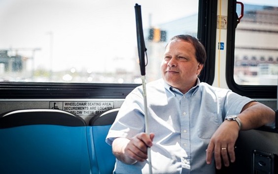 Blind person sitting on a metro bus
