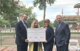 Officials holding grant agreement signing board