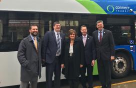 Transit officials pose in front of Bloomington, IL bus