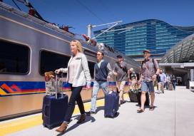 Image courtesy Paul Wedlake for RTD Passengers with suitcases board RTD commuter rail train outside Denver International Airport