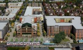 Aerial image of light rail train surrounded by development